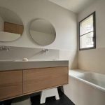 Salle de bain lumineuse en carrelage effet béton beige - associé au sol en tomettes noires - projet Kei-Stone