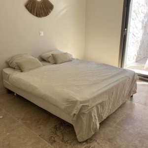 Le travertin posé au sol met en valeur la simplicité de la décoration de ce studio attendant à une villa contemporaine à Manosque dans le 04