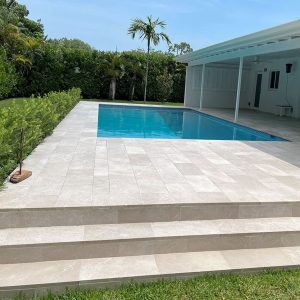 Piscine extérieure avec plage de bassin en carrelage effet pierre - sélection Beige Royal - chez Kei-Stone Aix en Pce