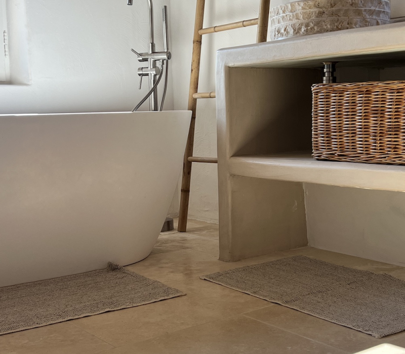 Aménagement d'une salle de bain design - baignoire ilot avec robinetterie - vasque en pierre naturelle et dallage naturelle - projet Kei-Stone