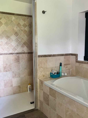 Salle de bain en pierre naturelle de travertin - formats carré et facile d'entretien - baignoire et douche italienne produits Kei-Stone